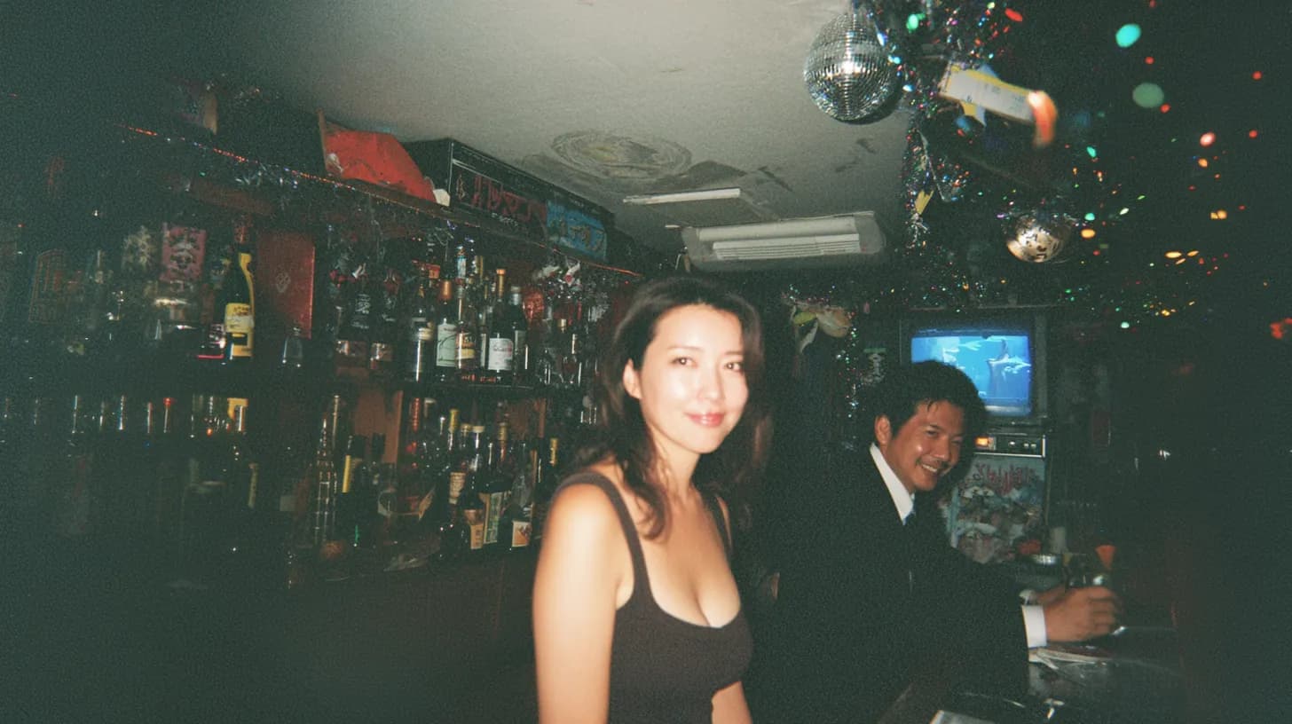 スナックのカウンターでくつろぐ女性と常連客。落ち着いた店内の居心地の良い雰囲気